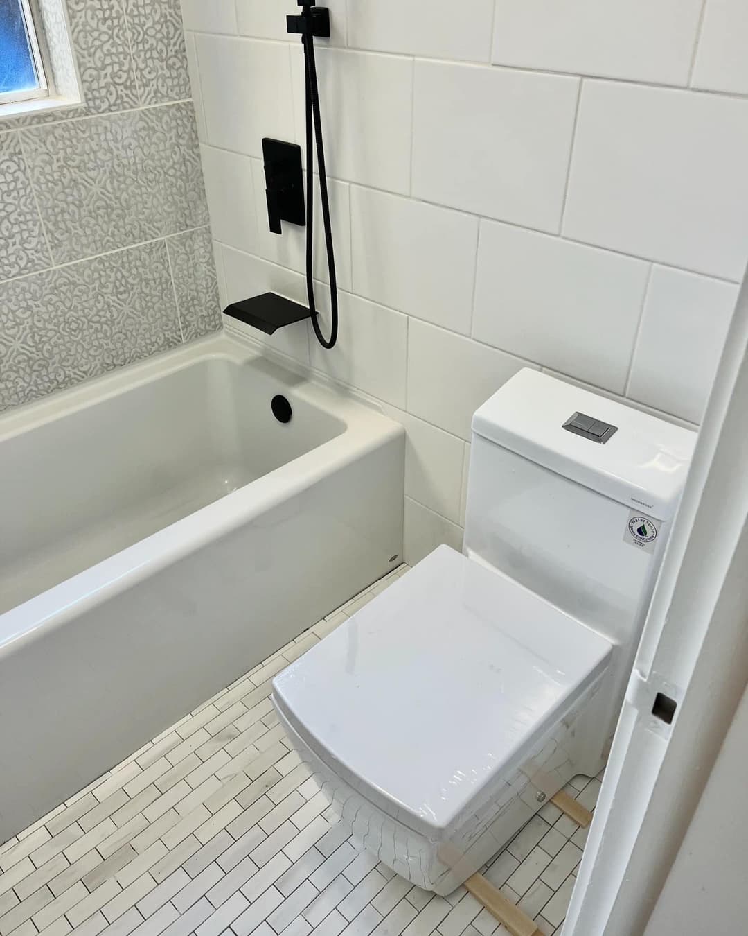 Modern bathroom featuring a white toilet, sleek shower, and stylish tile walls.
